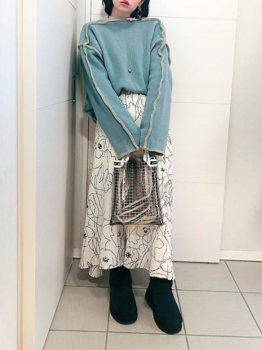 ブルー系のニット/セーター、ホワイト系のスカート、ブラック系のブーツを着用したレディースの冬コーディネートの1枚目の写真