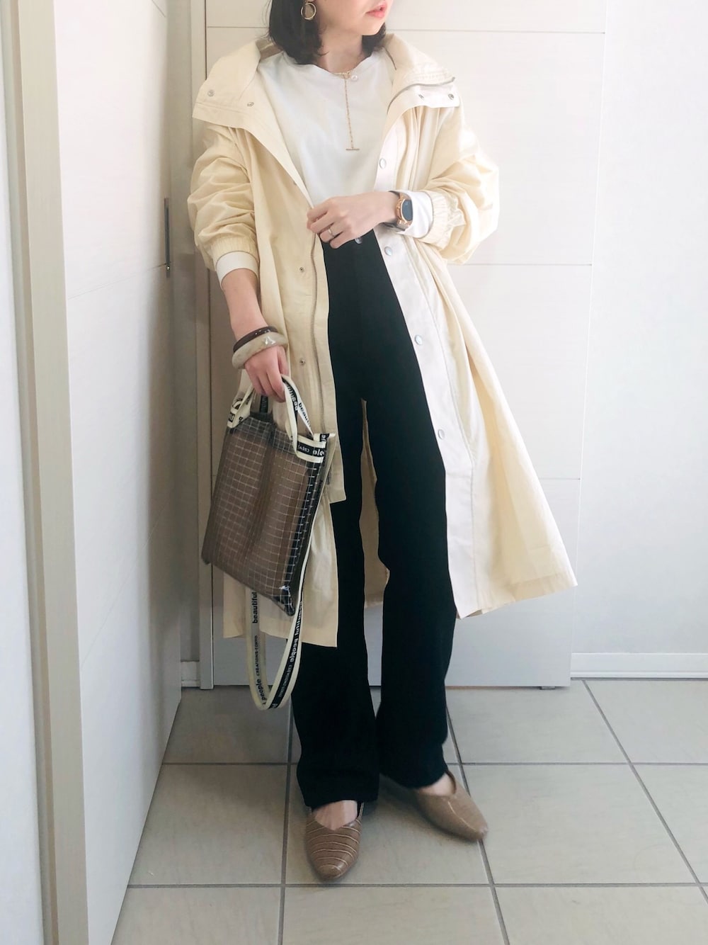 ホワイト系のマウンテンパーカー、ホワイト系のTシャツ/カットソー、ブラック系のデニムパンツを着用したレディースの春コーディネートの1枚目の写真