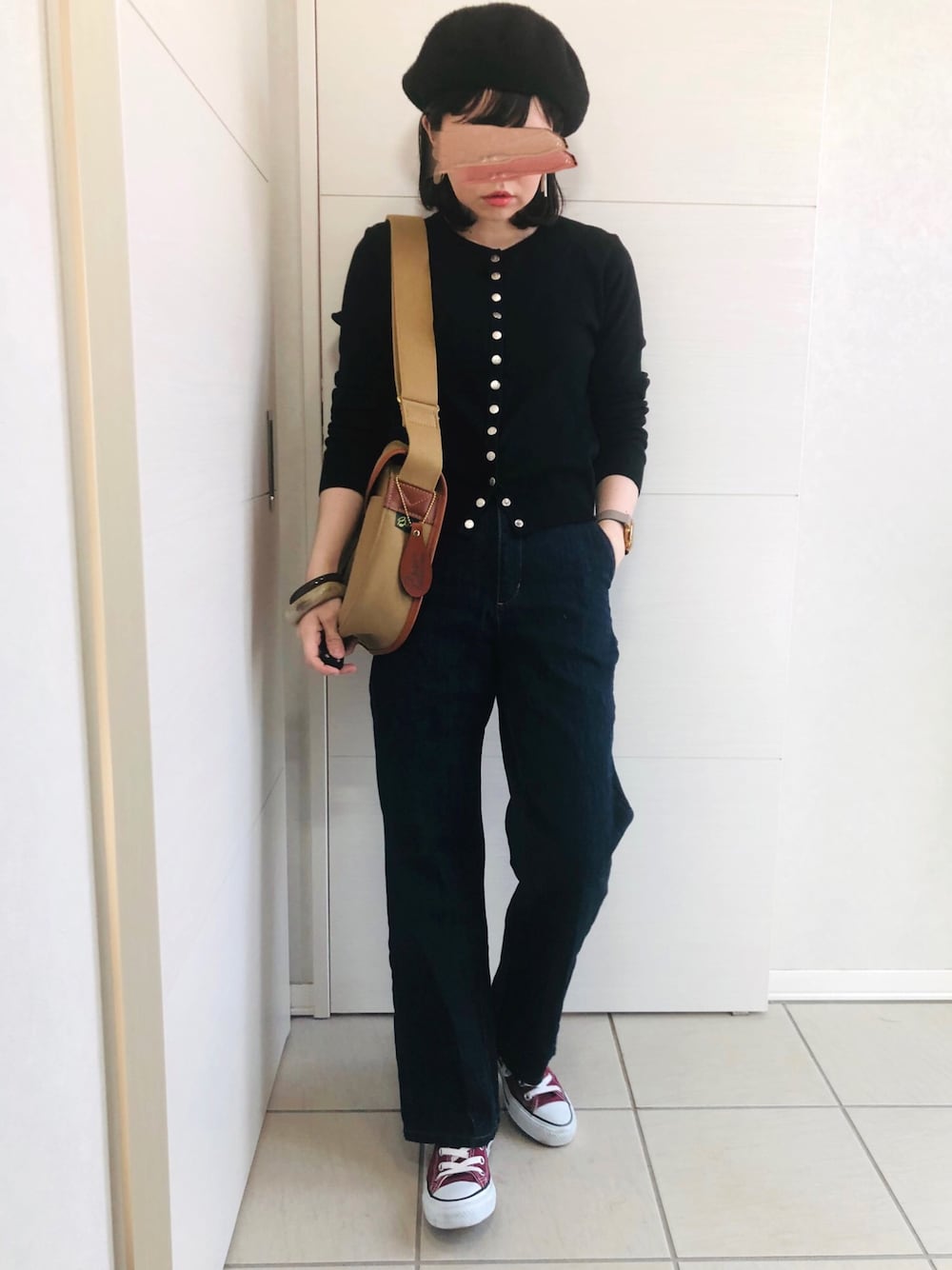 ブラック系のカーディガン/ボレロ、ブルー系のデニムパンツ、レッド系のスニーカーを着用したレディースの春コーディネートの1枚目の写真