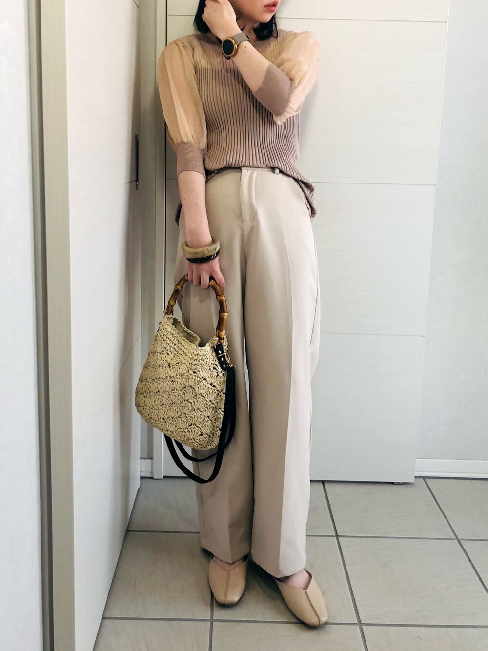 ベージュ系のニット/セーター、ホワイト系のスラックス、ベージュ系のパンプスを着用したレディースの春コーディネートの1枚目の写真