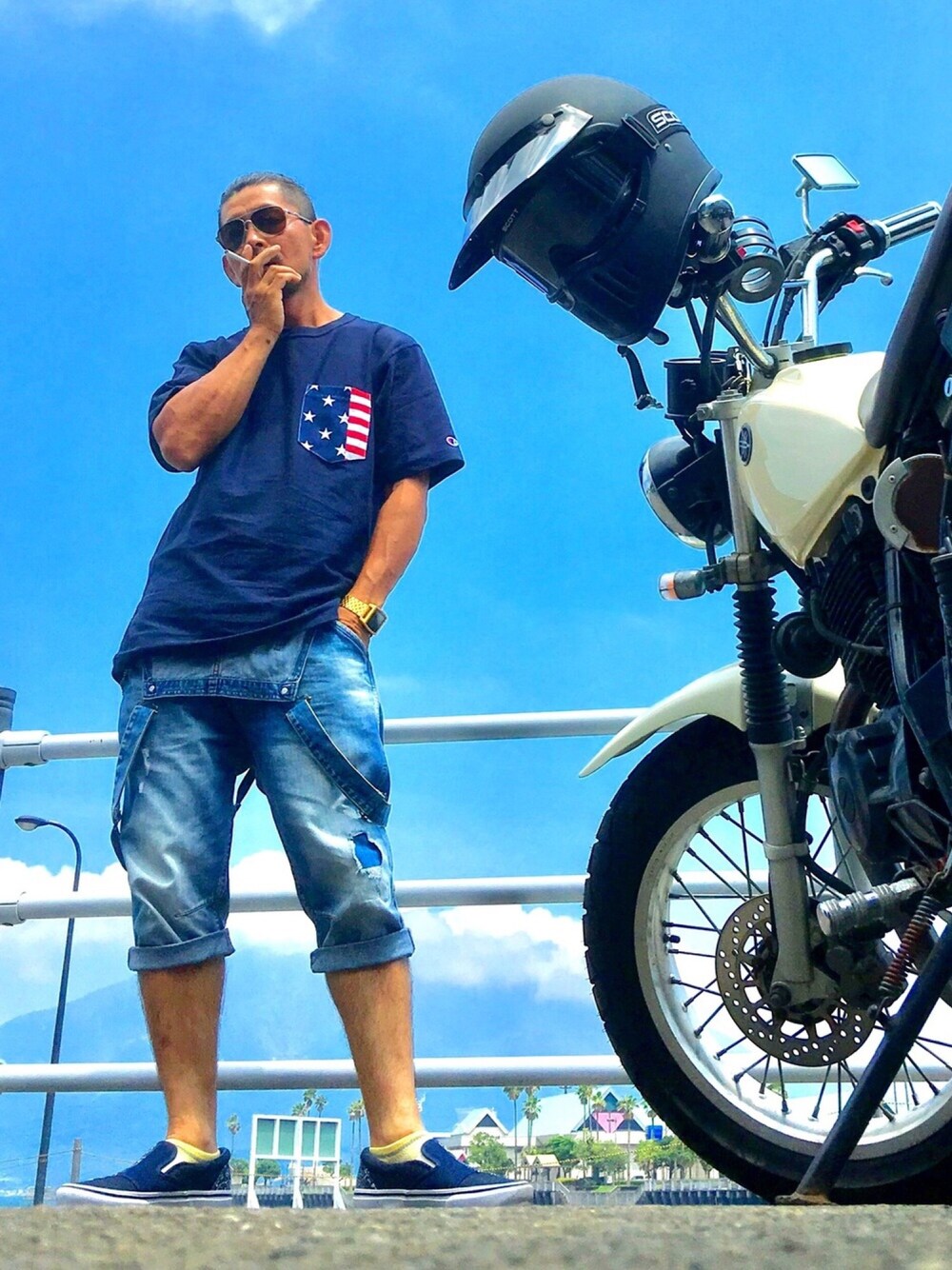 ブルー系のTシャツ/カットソー、ブルー系のサロペット/オーバーオール、ブルー系のスリッポンを着用したメンズの夏コーディネートの1枚目の写真