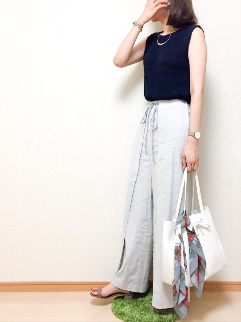 グレー系のその他パンツ、ベージュ系のサンダル、ブルー系のニット/セーターを着用したレディースの夏コーディネートの1枚目の写真