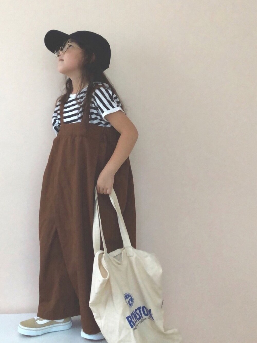 ブラウン系のサロペット/オーバーオール、ベージュ系のスニーカー、ブラック系のTシャツ/カットソーを着用したキッズの夏コーディネートの1枚目の写真