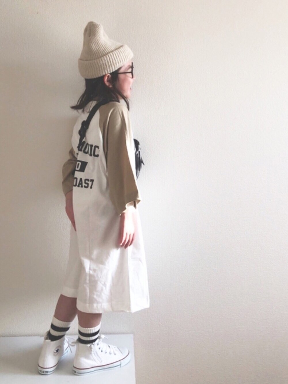 ベージュ系のワンピース、ホワイト系のスニーカー、ホワイト系のニットキャップ/ビーニーを着用したキッズの春コーディネートの1枚目の写真
