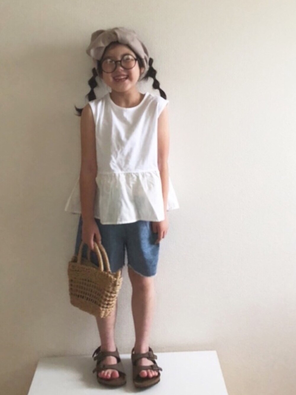 「ヘアバンド、サンダル、ハーフパンツ、ぺプラムトップス、めがね、丸メガネ、デニムパンツ、デニム、かごバッグ、玉ねぎヘア」｜「quoti use fithの26/- 天竺ティアードTシャツ（Tシャツ/カットソー、ホワイト系）」を使った、nami *さん（キッズ・110cm）の夏コーディネートの1枚目の写真