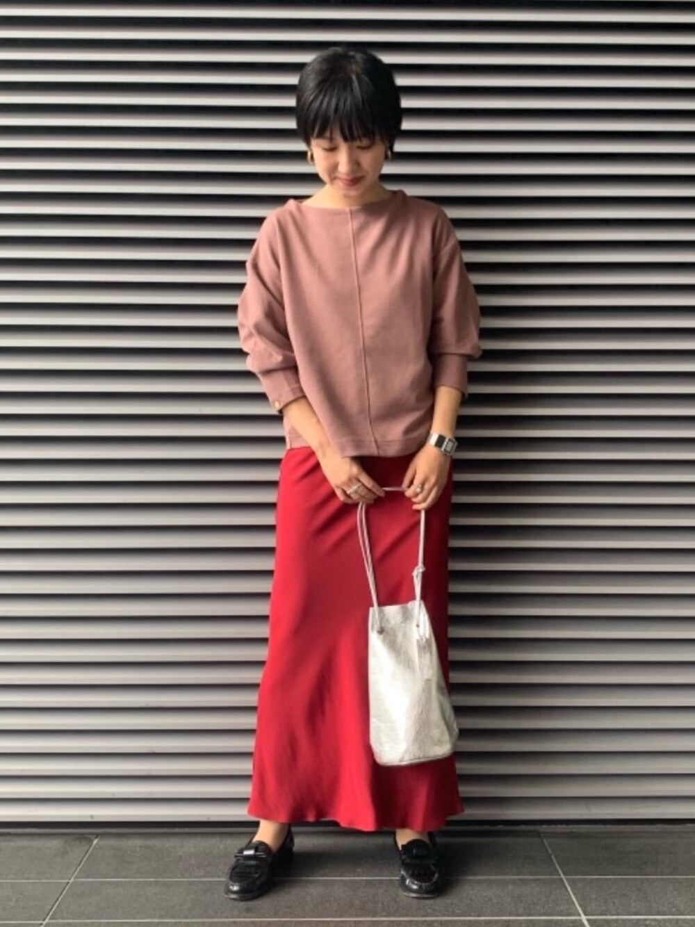レッド系のスカート、シルバー系のショルダーバッグ、ピンク系のTシャツ/カットソーを着用したレディースの秋コーディネートの1枚目の写真