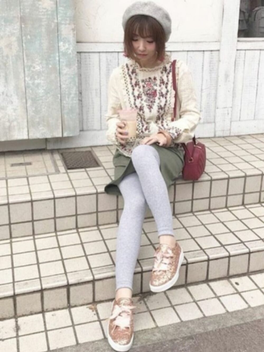 レッド系のスニーカーを着用したレディースの春コーディネートの1枚目の写真