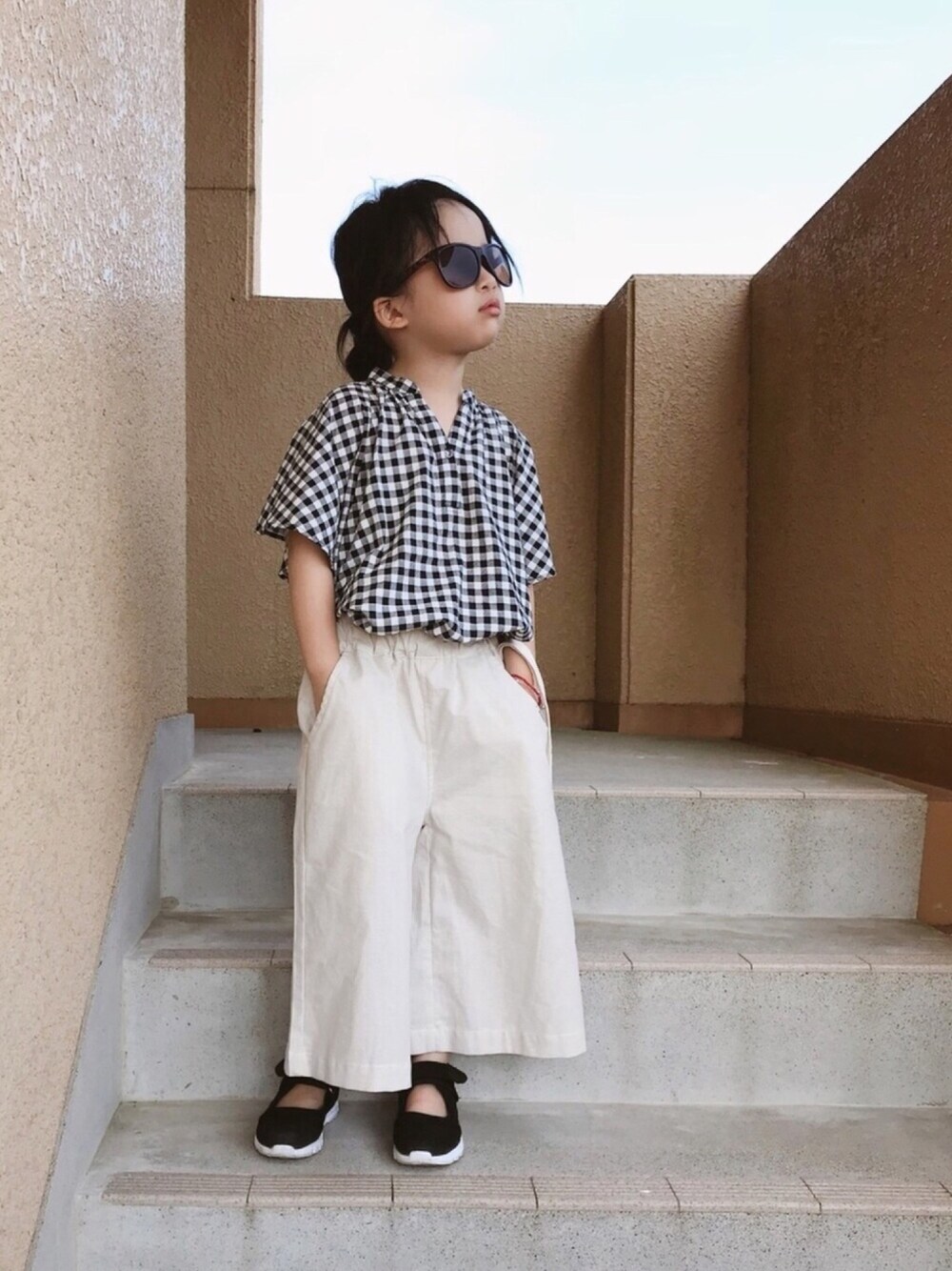 ブラック系のシャツ/ブラウス、ベージュ系のその他パンツ、ブラック系のスニーカーを着用したキッズの夏コーディネートの1枚目の写真