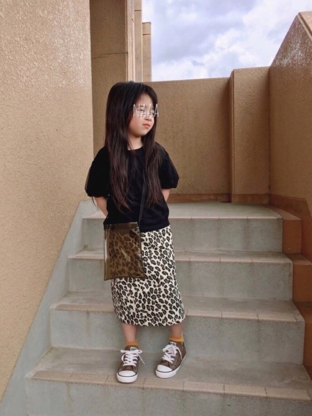 ブラック系のTシャツ/カットソー、ブラウン系のバッグ、ブラウン系のスニーカーを着用したキッズの春コーディネートの1枚目の写真