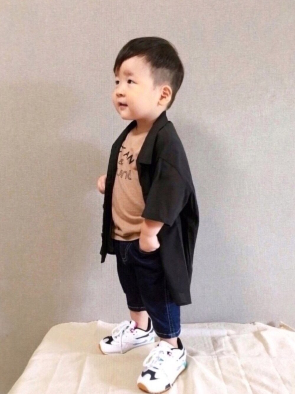 ブラウン系のTシャツ/カットソー、ブラック系のシャツ/ブラウス、ブルー系のデニムパンツを着用したキッズの秋コーディネートの1枚目の写真