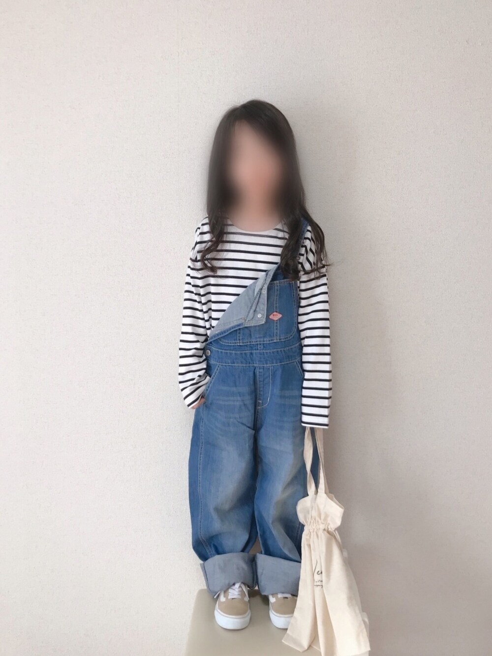 ブラック系のTシャツ/カットソー、ブルー系のサロペット/オーバーオール、ベージュ系のスニーカーを着用したキッズの冬コーディネートの1枚目の写真