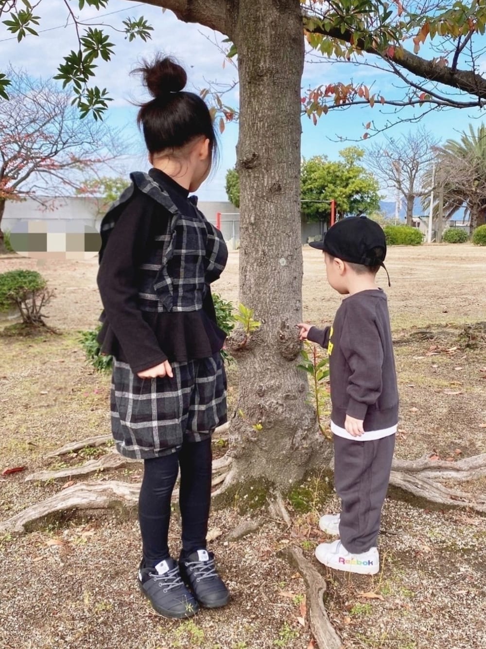 「セットアップ、ふりふり、ストリート系、レイヤードスタイル、ショートパンツ、チェック、お団子ヘアー、キャップ、ドッキング、公園」｜「petit mainのビスチェドッキング風リブプルオーバー×ショートパンツセット（アンサンブル、ブラック系）」を使った、naaaさん（キッズ・124cm）の秋コーディネートの1枚目の写真