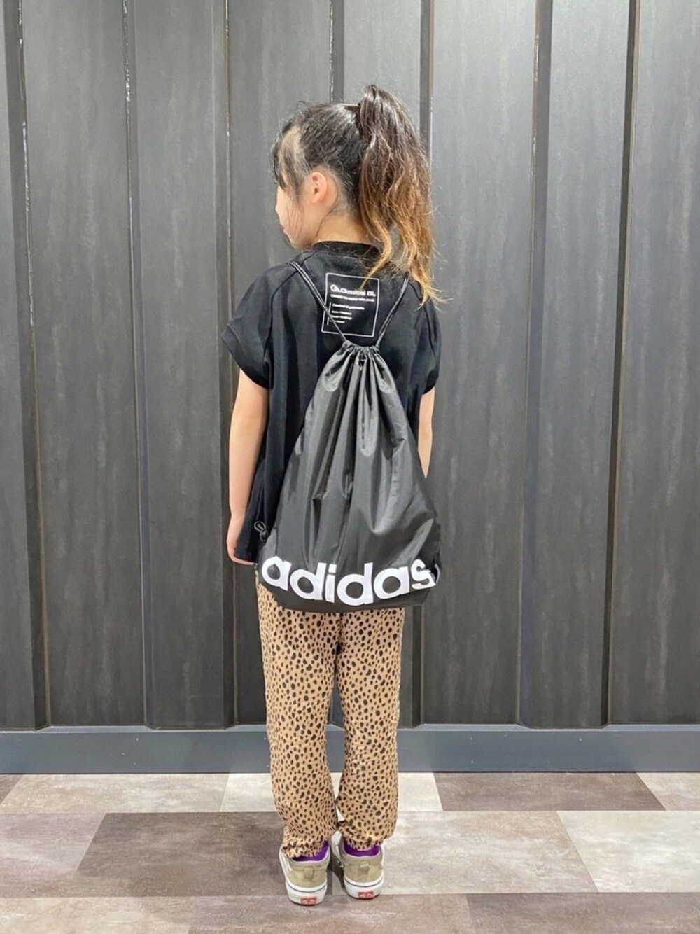 ブラック系のTシャツ/カットソー、ブラウン系のパンツ、ブラック系のエコバッグ/サブバッグを着用したキッズの春コーディネートの1枚目の写真