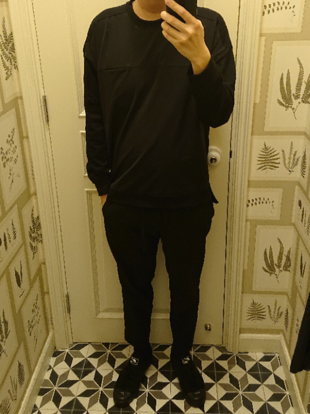 ブラック系のスウェット、ブラック系のチノパンツ、ブラック系のスニーカーを着用したメンズの春コーディネートの1枚目の写真