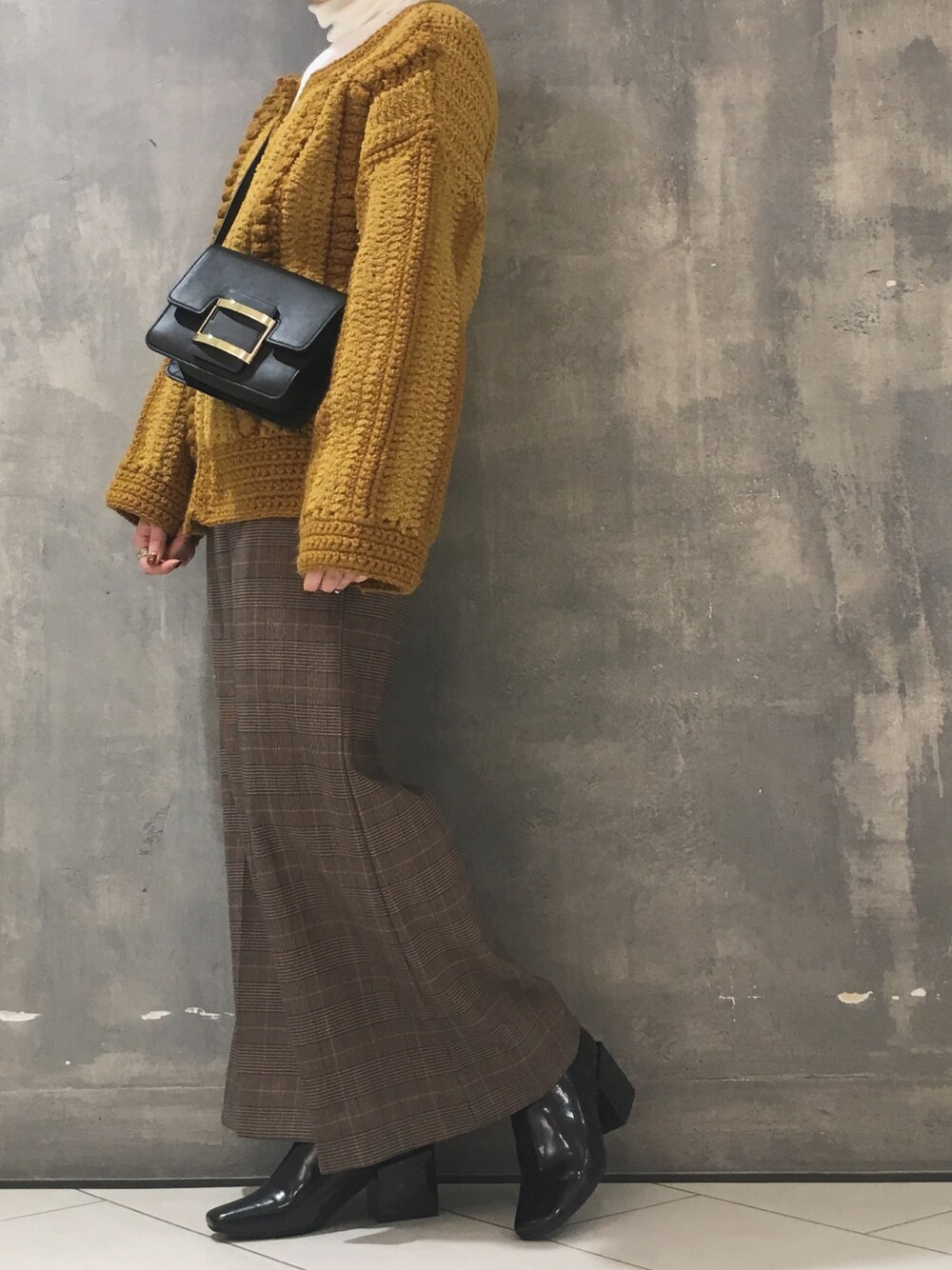 ブラウン系のその他パンツ、イエロー系のカーディガン/ボレロ、ブラック系のショルダーバッグを着用したレディースの冬コーディネートの1枚目の写真