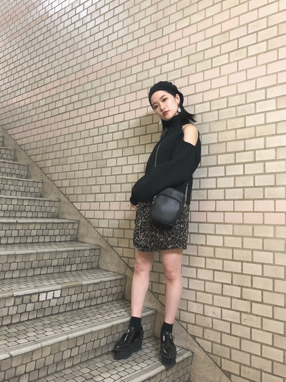 ブラック系のニット/セーター、ブラック系のショルダーバッグ、ブラック系のローファーを着用したレディースの冬コーディネートの1枚目の写真