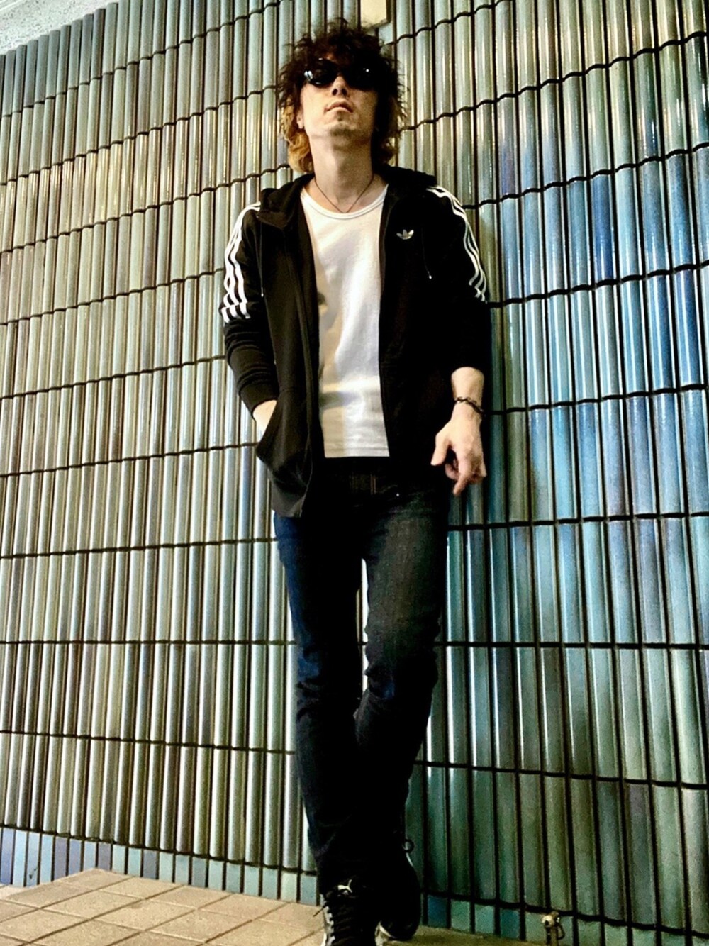 ブラック系のパーカー、ホワイト系のTシャツ/カットソー、ブルー系のデニムパンツを着用したメンズの秋コーディネートの1枚目の写真