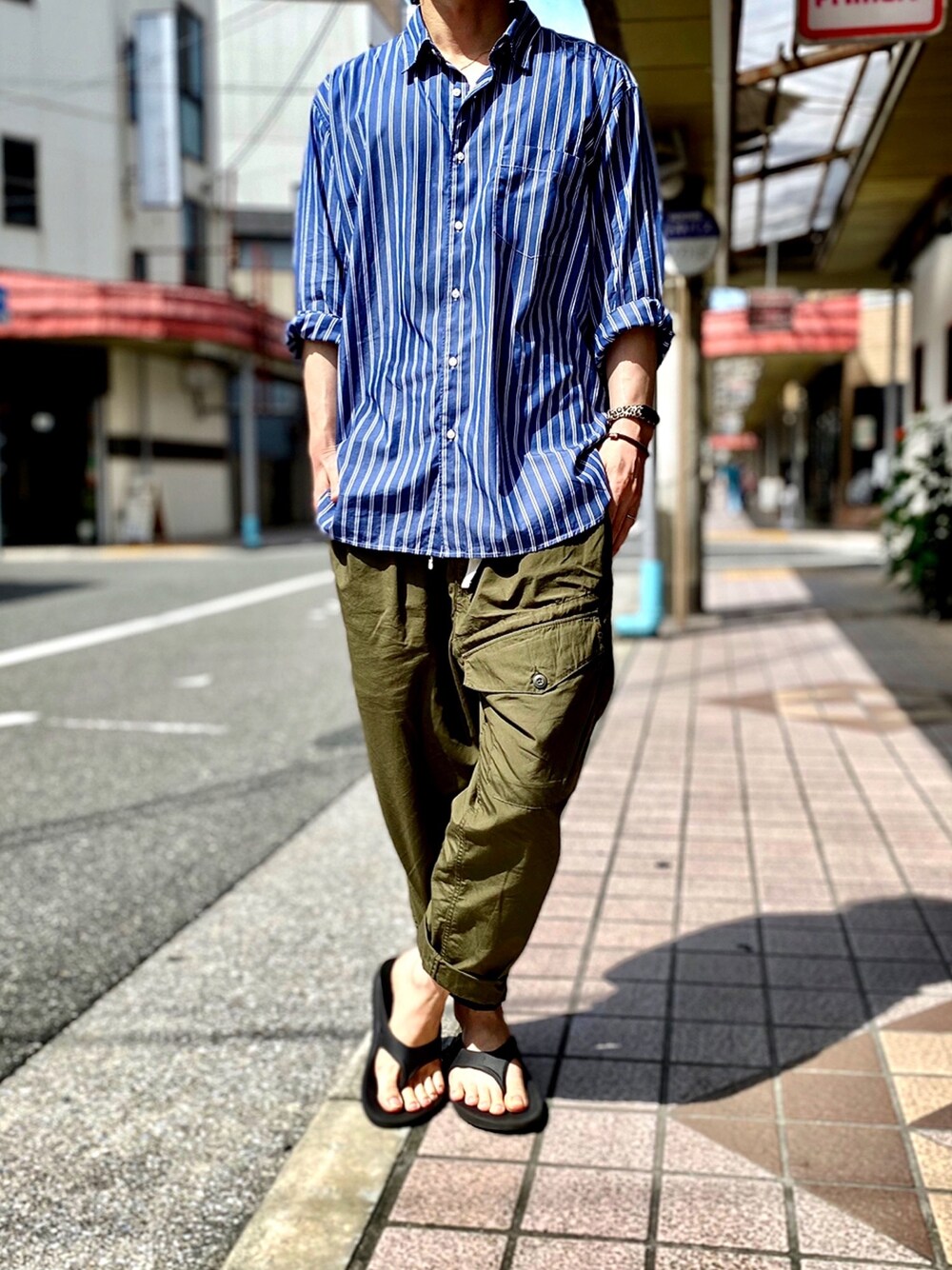 ブルー系のシャツ/ブラウス、グリーン系のカーゴパンツ、ブラック系のサンダルを着用したメンズの夏コーディネートの1枚目の写真