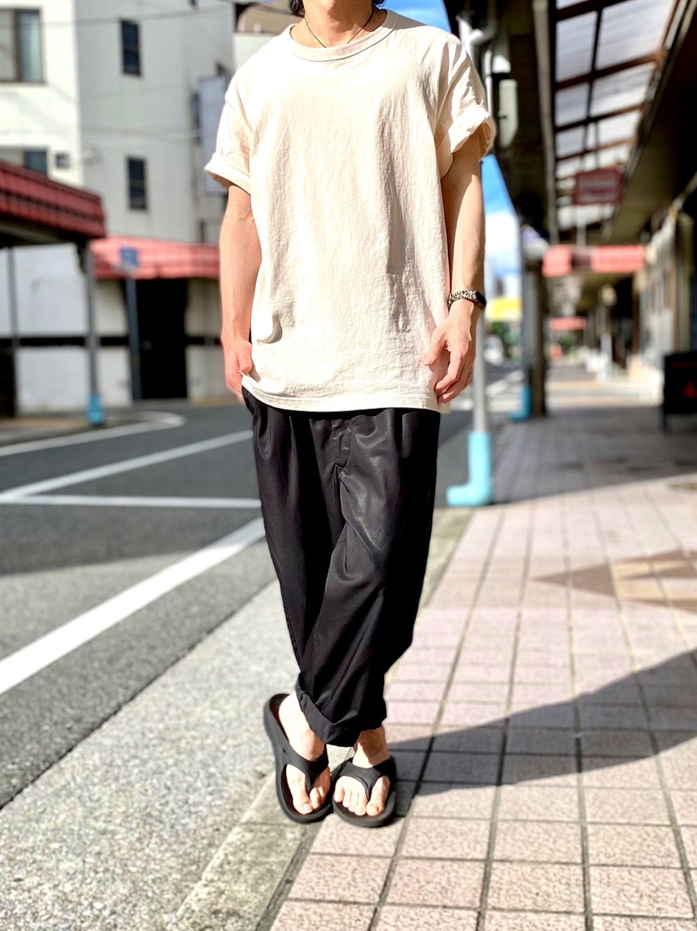 ベージュ系のTシャツ/カットソー、ブラック系のその他パンツ、ブラック系のサンダルを着用したメンズの秋コーディネートの1枚目の写真