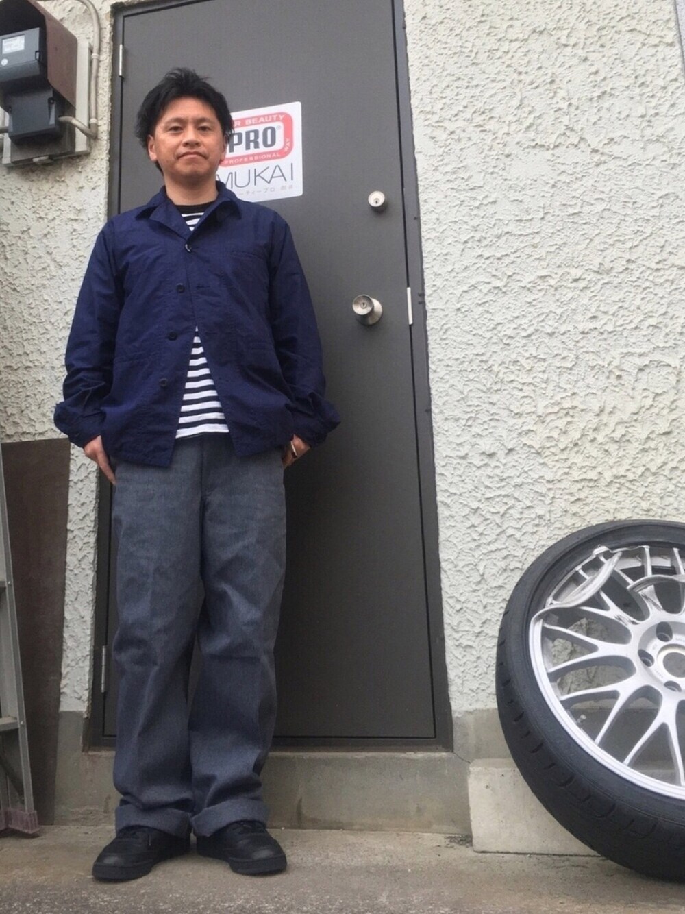 ブラック系のスニーカー、グレー系のパンツ、ブラック系のTシャツ/カットソーを着用したメンズの春コーディネートの1枚目の写真