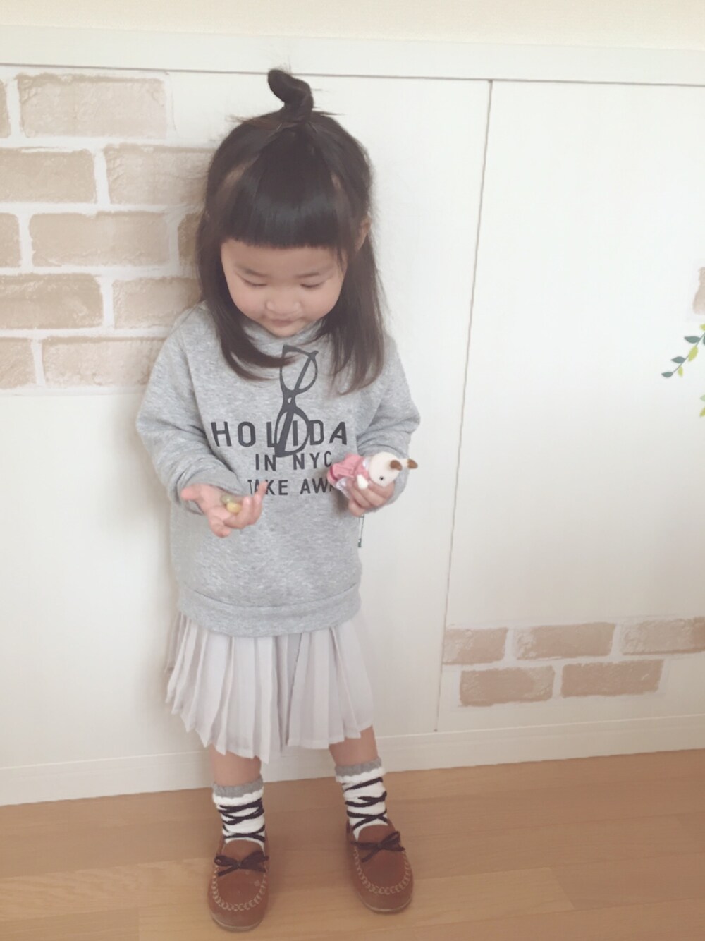 グレー系のパーカー、グレー系のスカート、ブラウン系のモカシン/デッキシューズを着用したキッズの春コーディネートの1枚目の写真