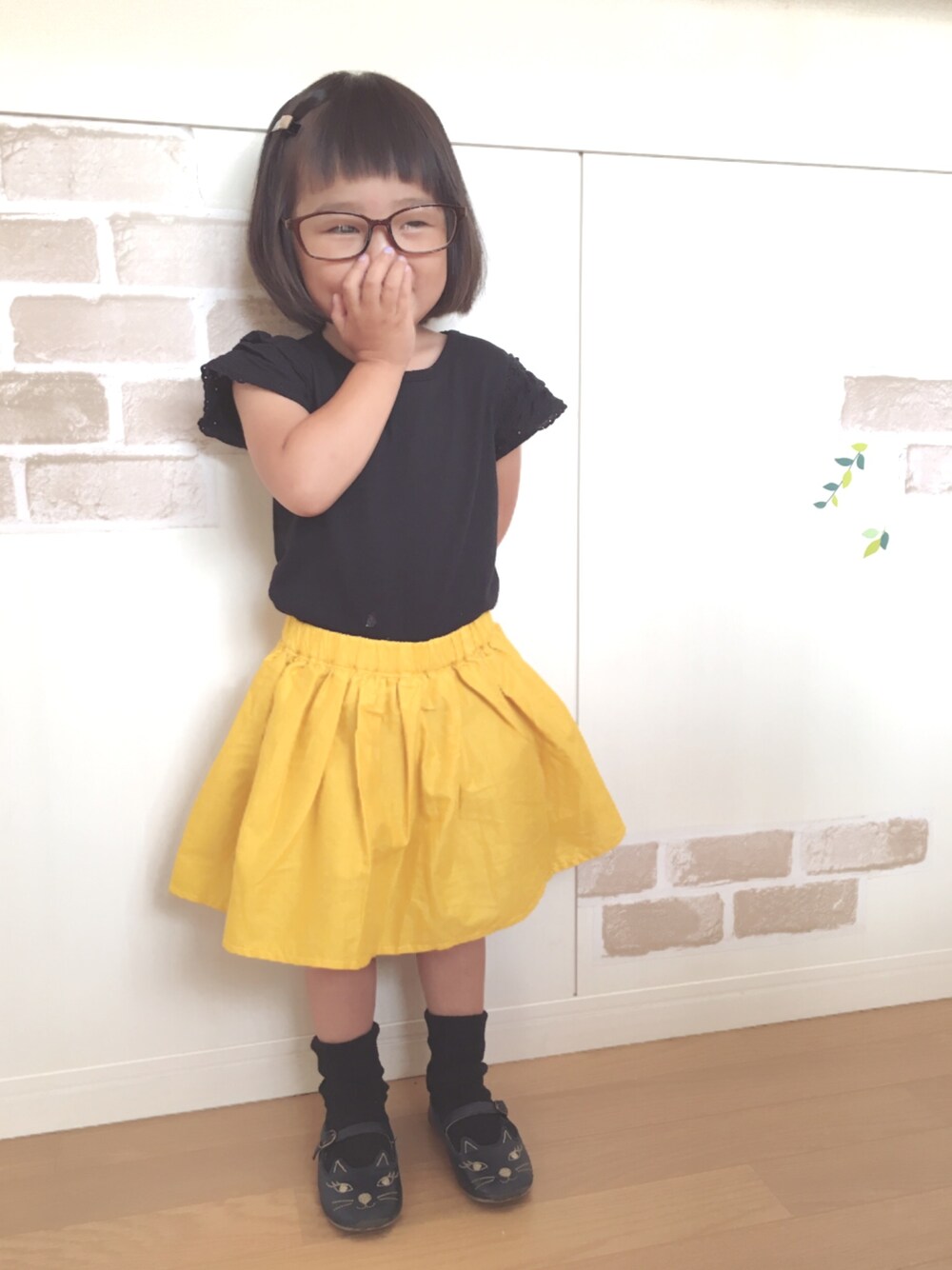 ブラック系のTシャツ/カットソー、イエロー系のスカート、ブルー系のバレエシューズを着用したキッズの夏コーディネートの1枚目の写真