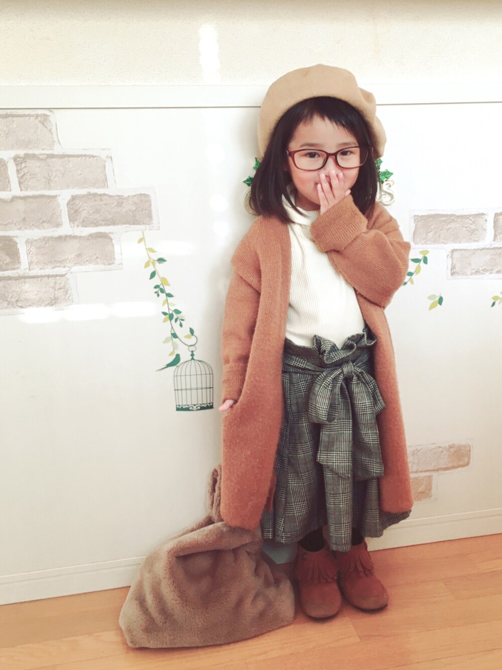 ブラウン系のカーディガン/ボレロ、グレー系のスカート、ベージュ系のトートバッグを着用したキッズの秋コーディネートの1枚目の写真