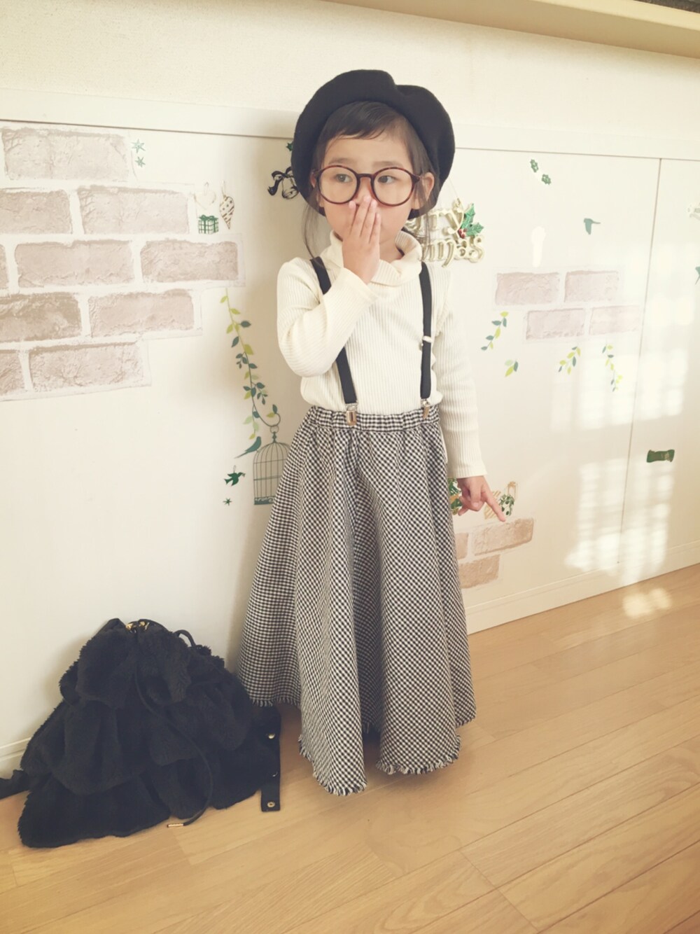 ホワイト系のニット/セーター、ホワイト系のスカート、ブラック系のバックパック/リュックを着用したキッズの冬コーディネートの1枚目の写真