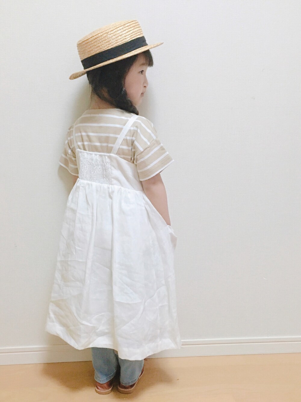 ベージュ系のTシャツ/カットソー、ホワイト系のワンピース、ブラウン系のサンダルを着用したキッズの春コーディネートの1枚目の写真