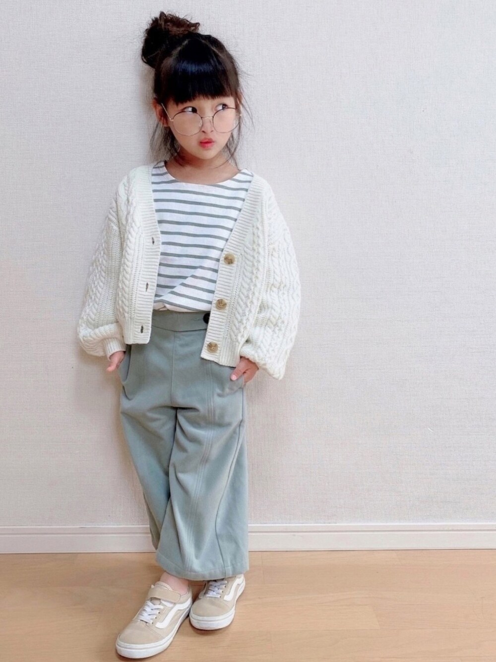 ホワイト系のカーディガン/ボレロ、グリーン系のTシャツ/カットソー、ブルー系のパンツを着用したキッズの冬コーディネートの1枚目の写真