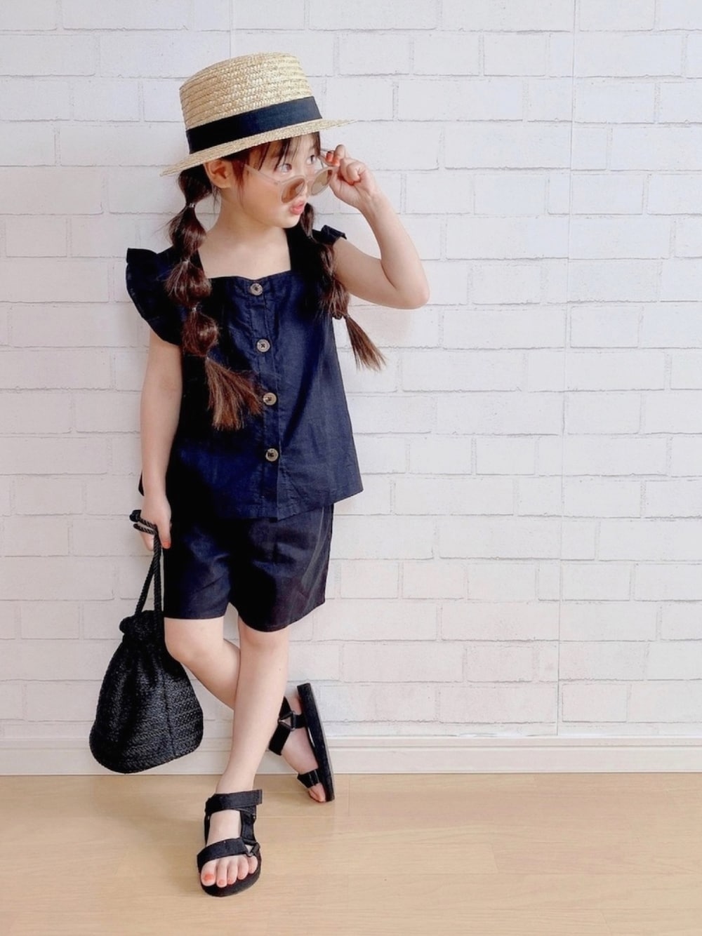 ブラック系のパンツ、ブラック系のパンツ、ブラック系のバッグを着用したキッズの春コーディネートの1枚目の写真