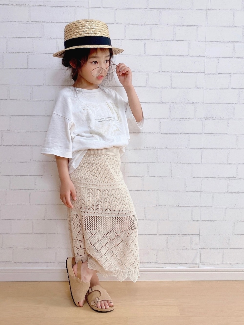 ホワイト系のTシャツ/カットソー、ベージュ系のスカート、ブラウン系のシューズを着用したキッズの夏コーディネートの1枚目の写真