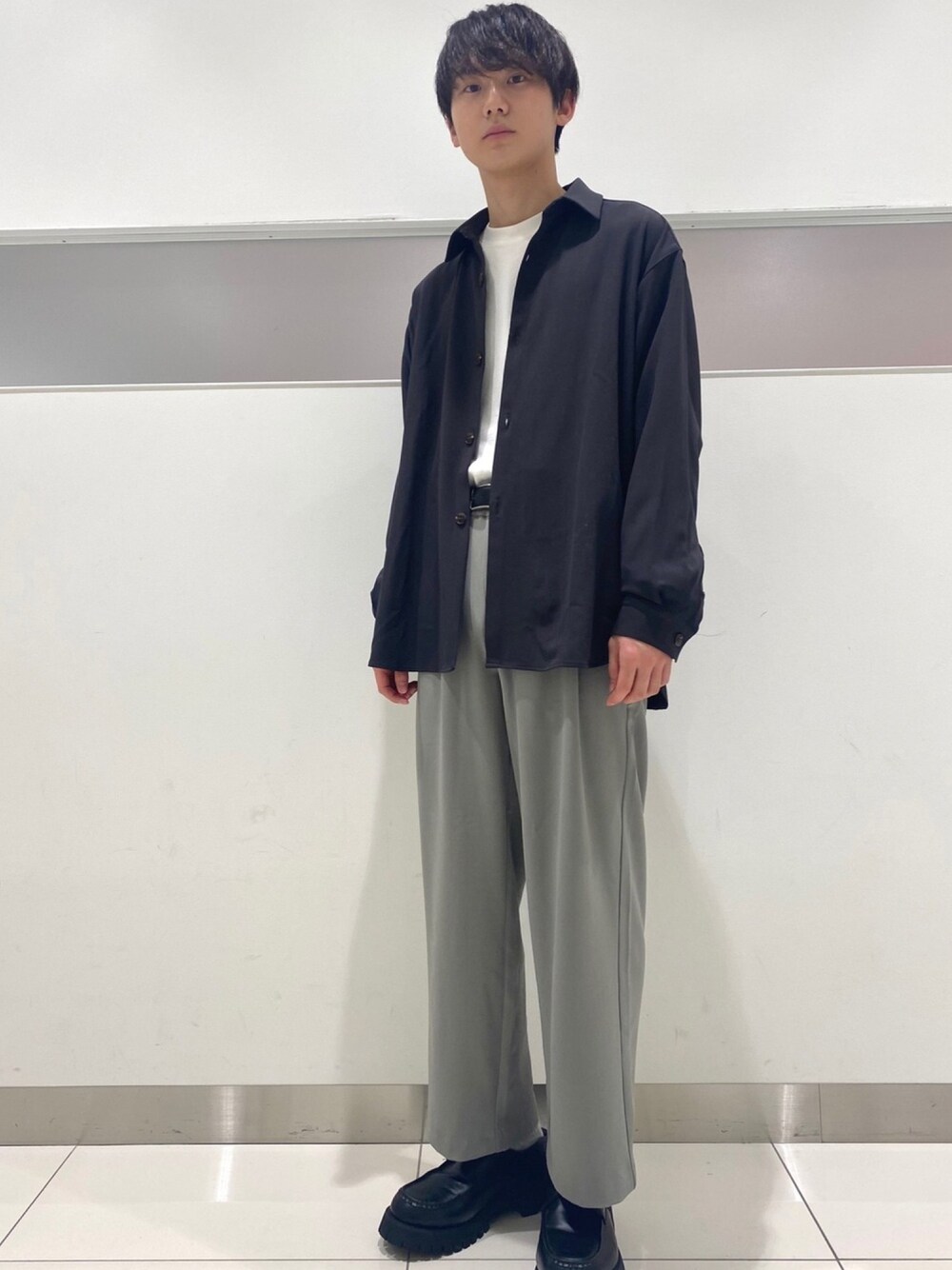 グレー系のシャツ/ブラウス、ホワイト系のTシャツ/カットソー、グリーン系のスラックスを着用したメンズの冬コーディネートの1枚目の写真