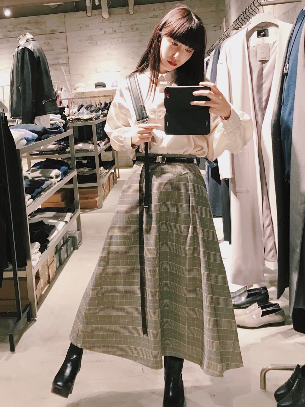 ブラウン系のスカート、ベージュ系のシャツ/ブラウス、ブラック系のバックパック/リュックを着用したレディースの冬コーディネートの1枚目の写真