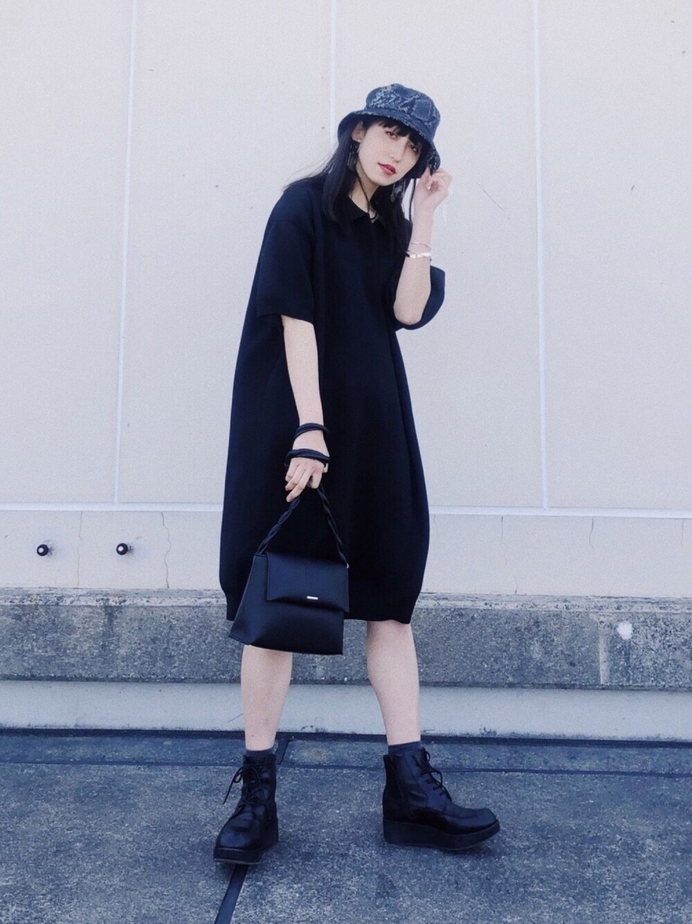 ブラック系のワンピース、ブラック系のショルダーバッグ、その他のハットを着用したレディースの春コーディネートの1枚目の写真