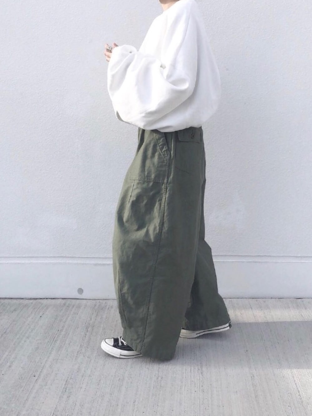 ホワイト系のスウェット、グリーン系のパンツを着用したレディースの冬コーディネートの1枚目の写真