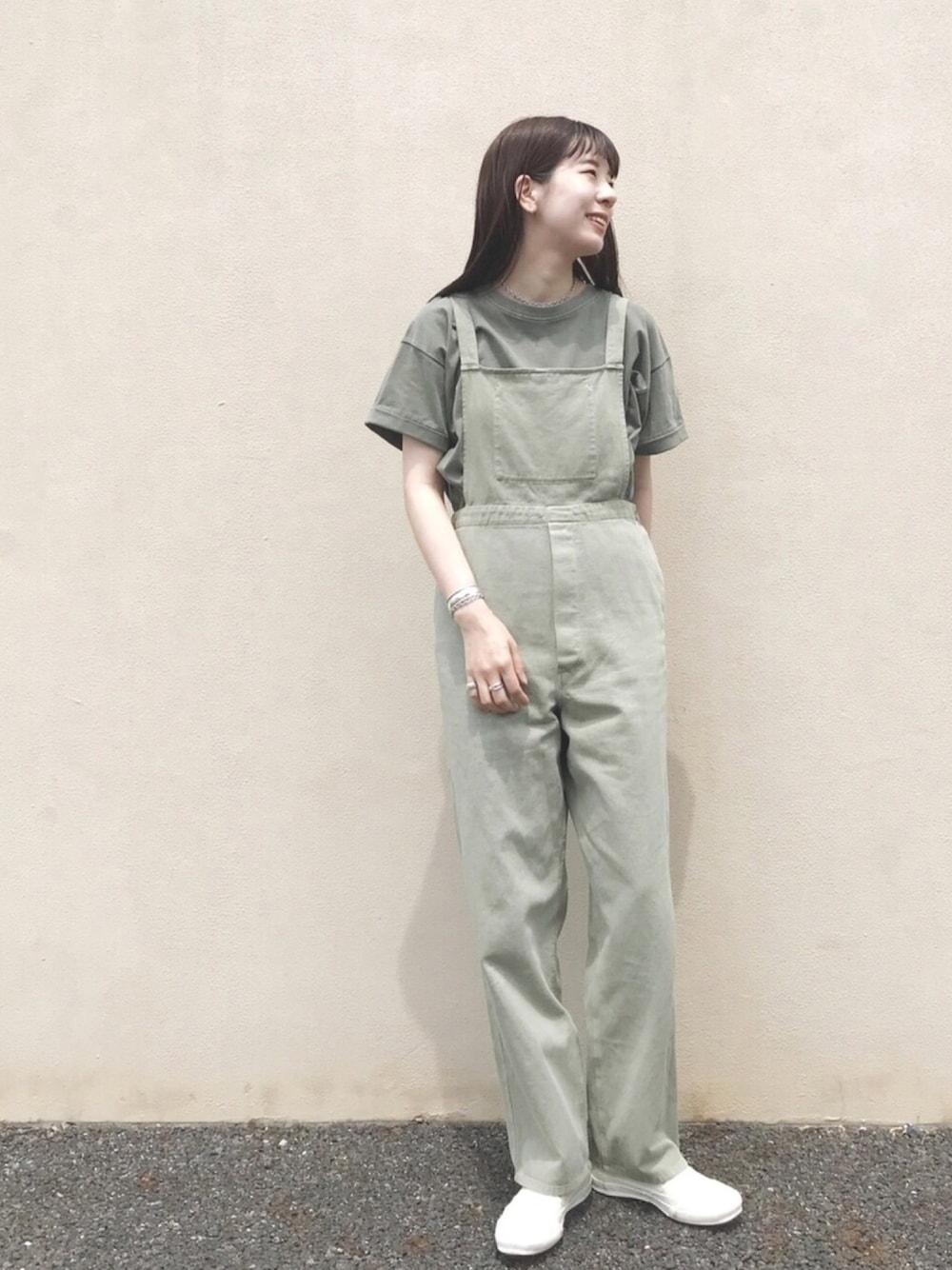 グリーン系のTシャツ/カットソー、グリーン系のサロペット/オーバーオール、ホワイト系のシューズを着用したレディースの春コーディネートの1枚目の写真