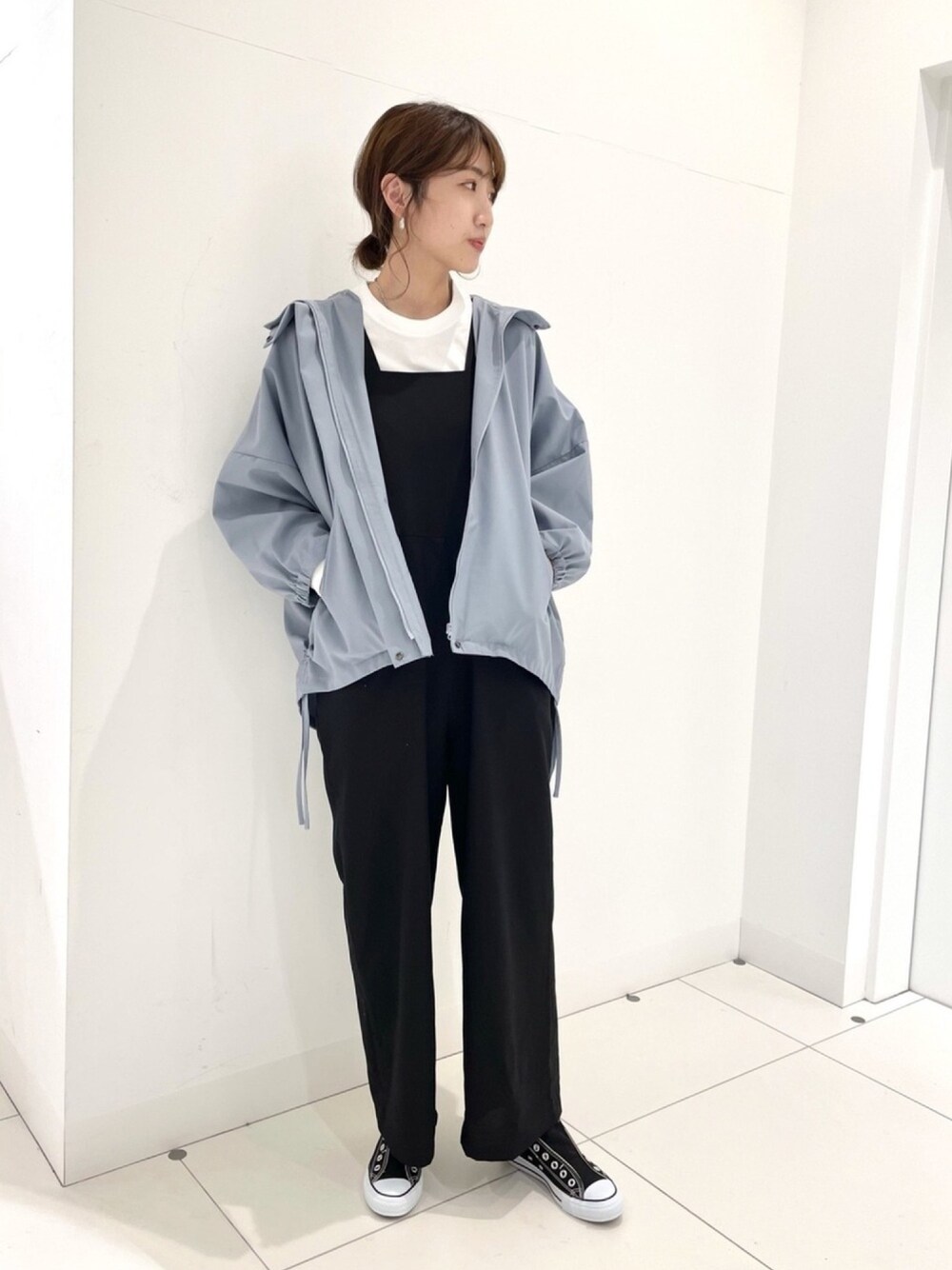 ブラック系のスリッポン、ブルー系のマウンテンパーカー、ホワイト系のTシャツ/カットソーを着用したレディースの春コーディネートの1枚目の写真