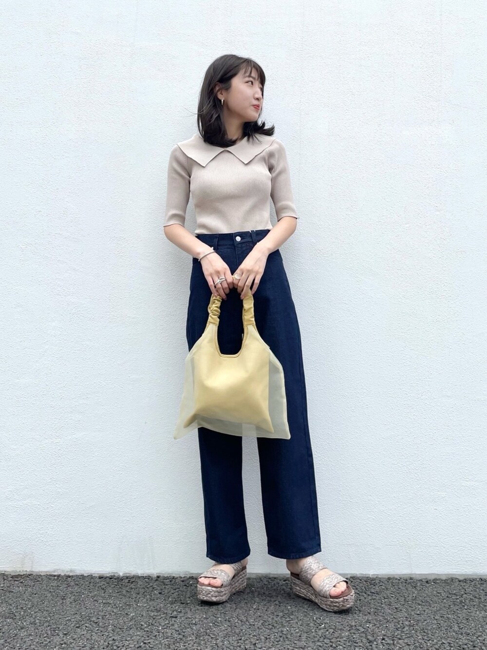 ベージュ系のニット/セーター、イエロー系のショルダーバッグ、ブルー系のその他パンツを着用したレディースの夏コーディネートの1枚目の写真