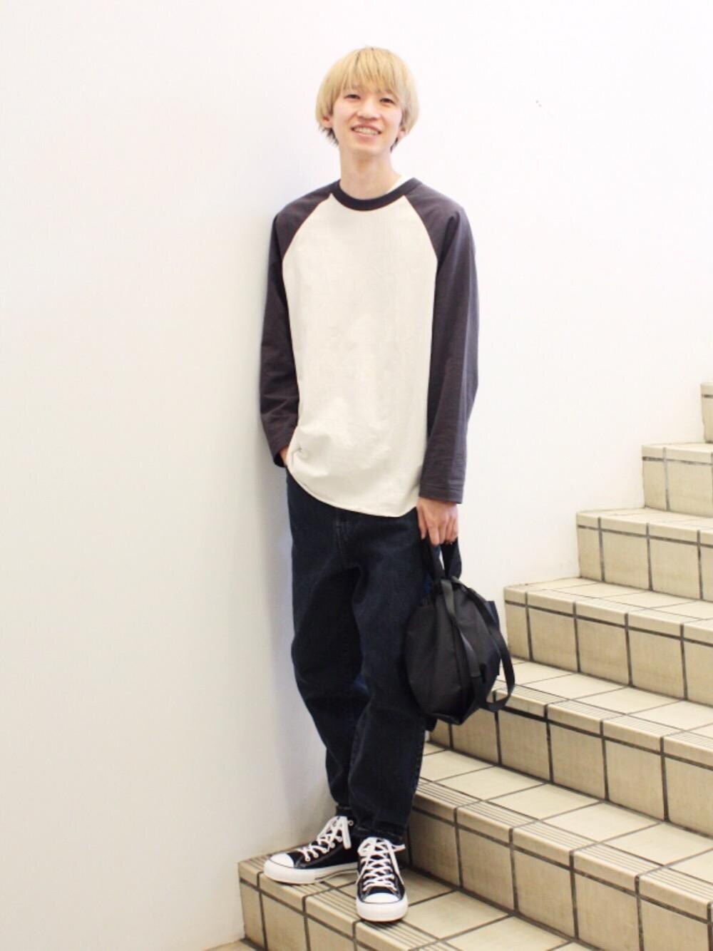 グレー系のTシャツ/カットソー、ブラック系のスニーカー、グレー系のデニムパンツを着用したメンズの春コーディネートの1枚目の写真