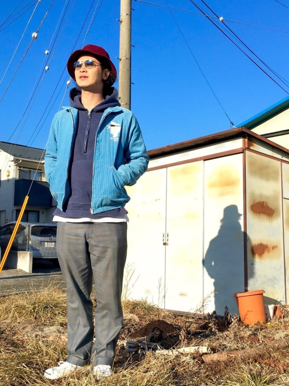 ブルー系のパーカー、ブルー系のその他アウター、グレー系のスラックスを着用したメンズの冬コーディネートの1枚目の写真