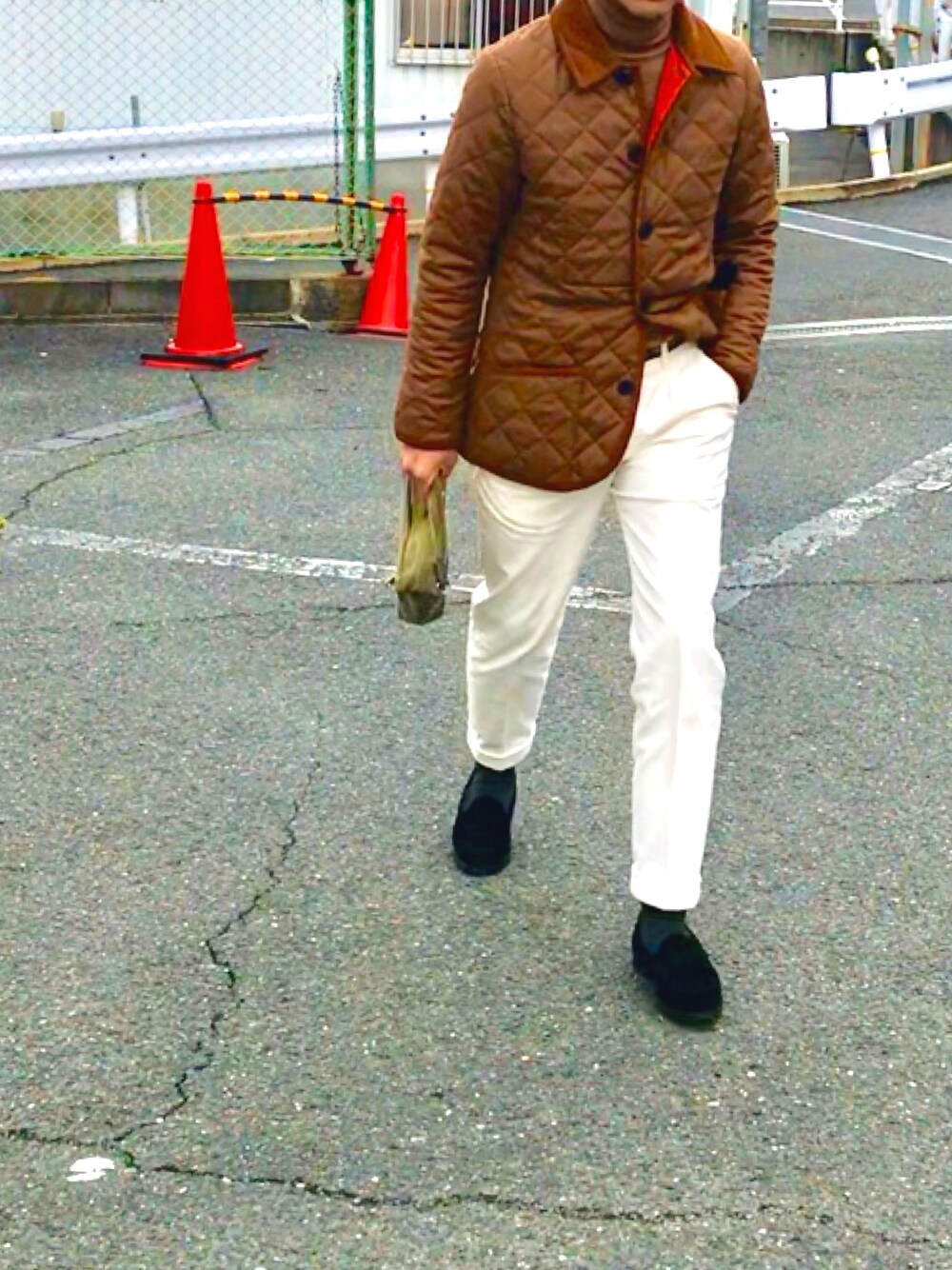 ホワイト系のスラックス、ブラック系のローファーを着用したメンズの春コーディネートの1枚目の写真