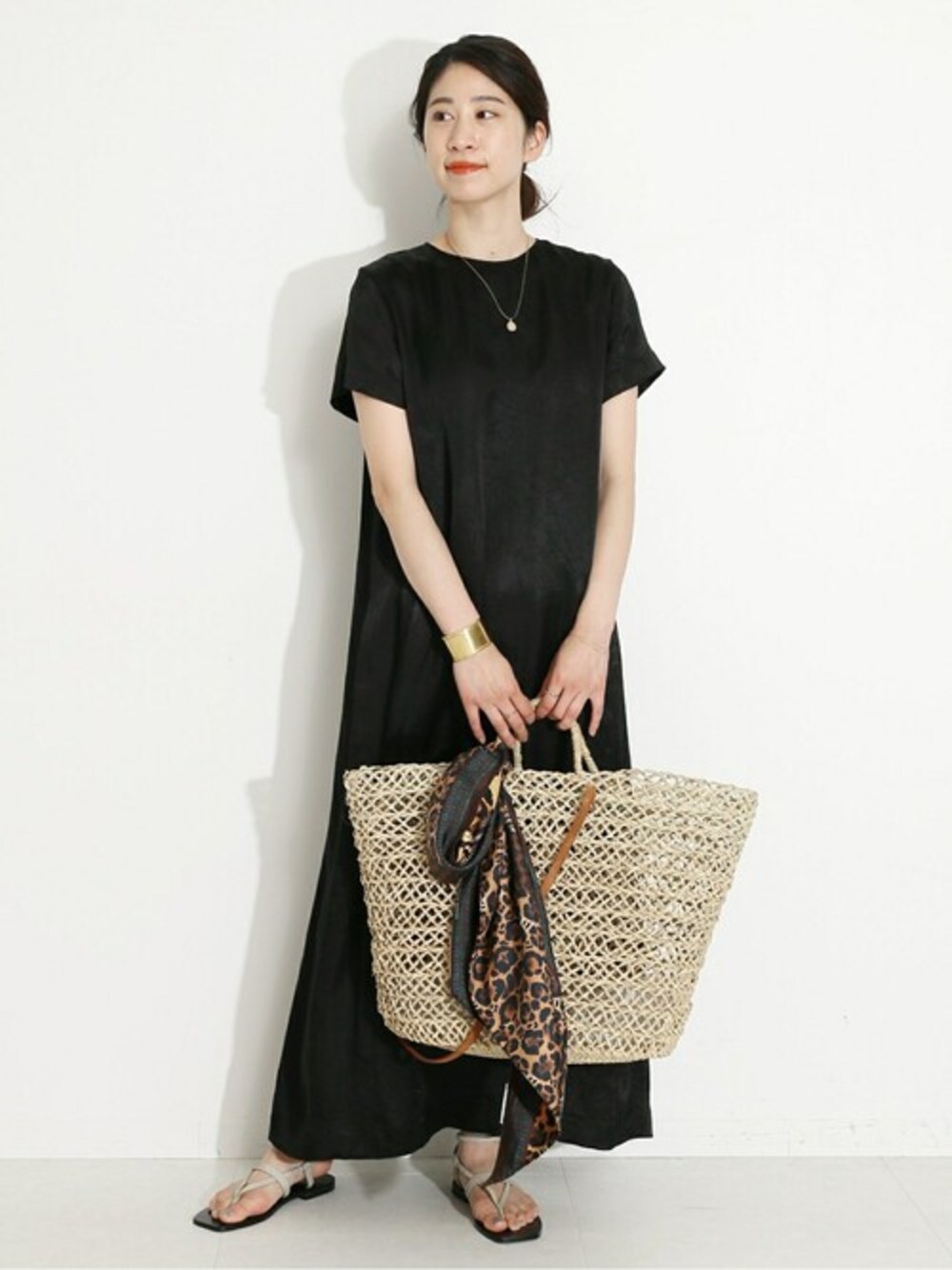 ブラック系のワンピース、その他のサンダル、ベージュ系のネックレスを着用したレディースの春コーディネートの1枚目の写真