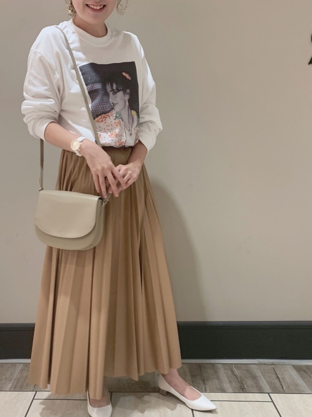 ホワイト系のTシャツ/カットソー、イエロー系のスカート、ベージュ系のショルダーバッグを着用したレディースの夏コーディネートの1枚目の写真