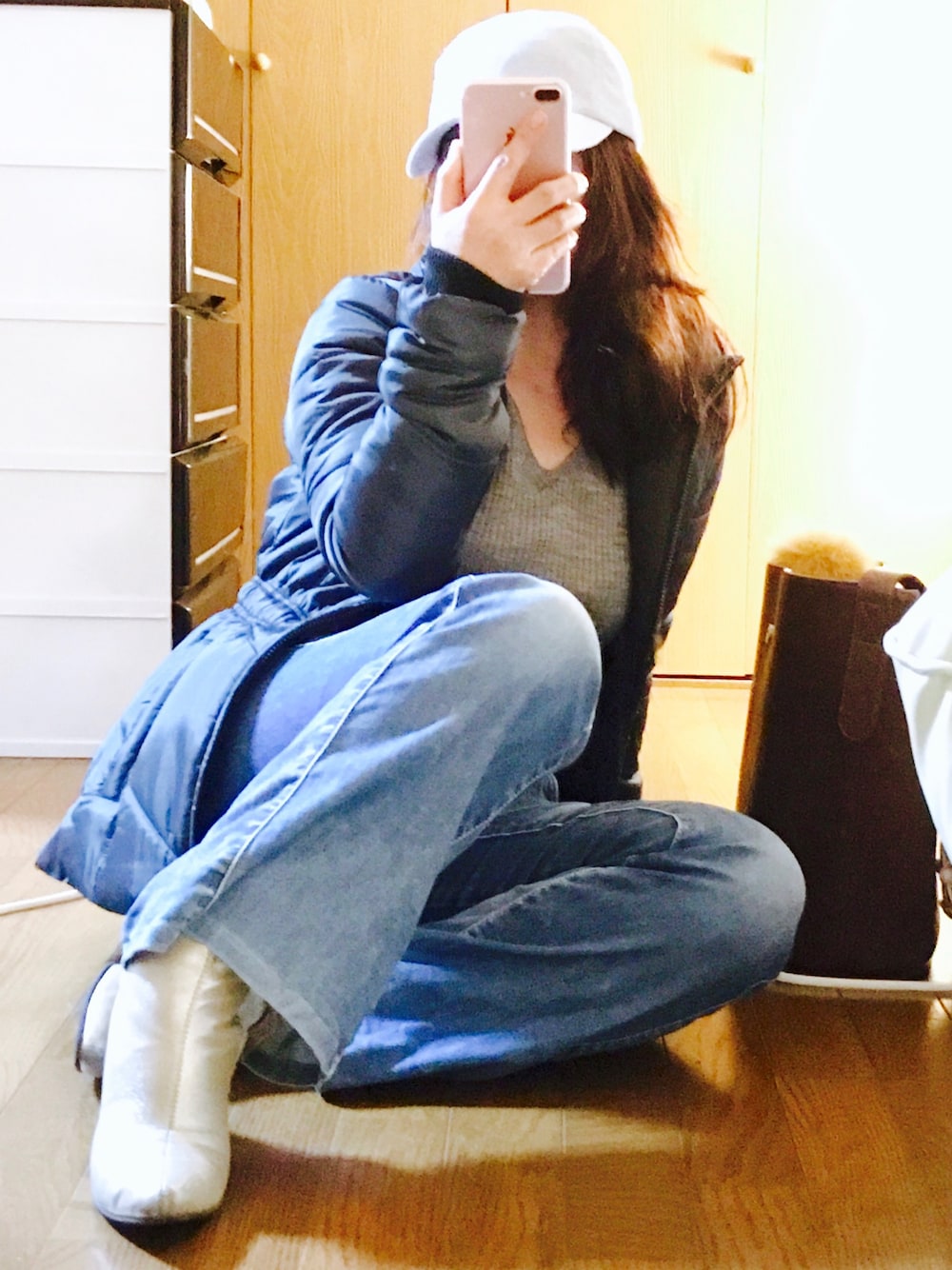 グレー系のミリタリージャケット、グレー系のニット/セーター、ブルー系のデニムパンツを着用したレディースの冬コーディネートの1枚目の写真