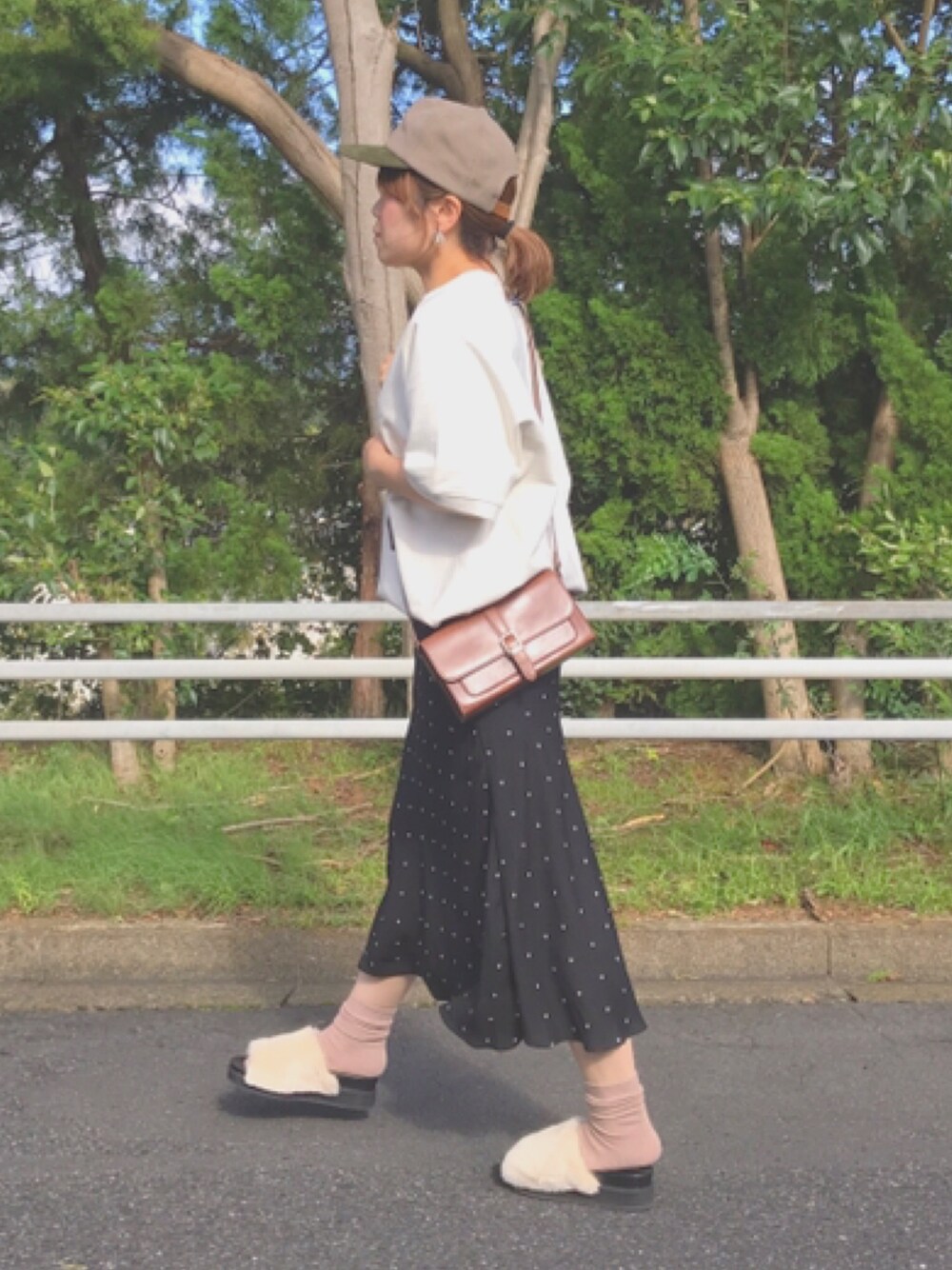 ホワイト系のスウェット、ベージュ系のサンダル、ベージュ系のキャップを着用したレディースの秋コーディネートの1枚目の写真