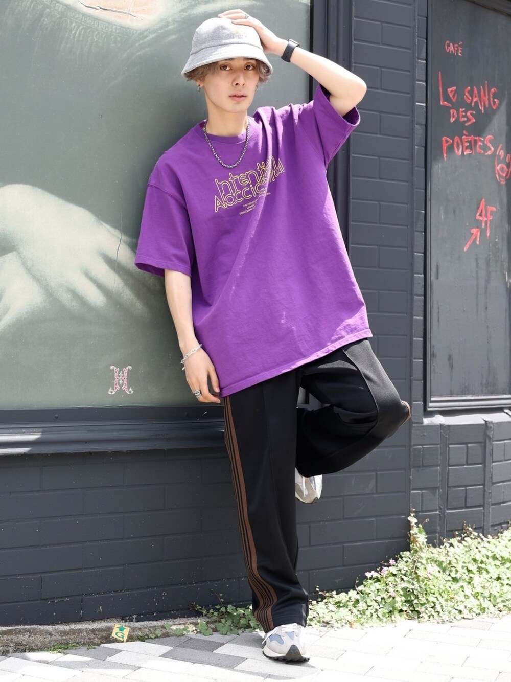 パープル系のTシャツ/カットソー、ブラック系のパンツ、グレー系のスニーカーを着用したメンズの春コーディネートの1枚目の写真