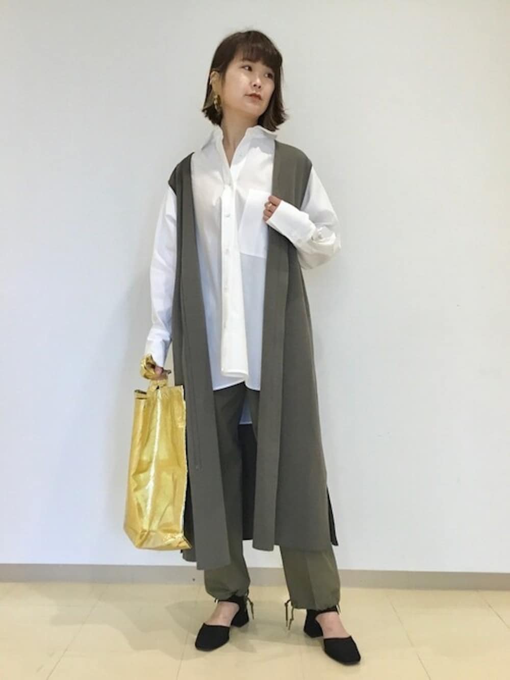 ホワイト系のシャツ/ブラウス、グレー系のニット/セーター、グリーン系のその他パンツを着用したレディースの春コーディネートの1枚目の写真