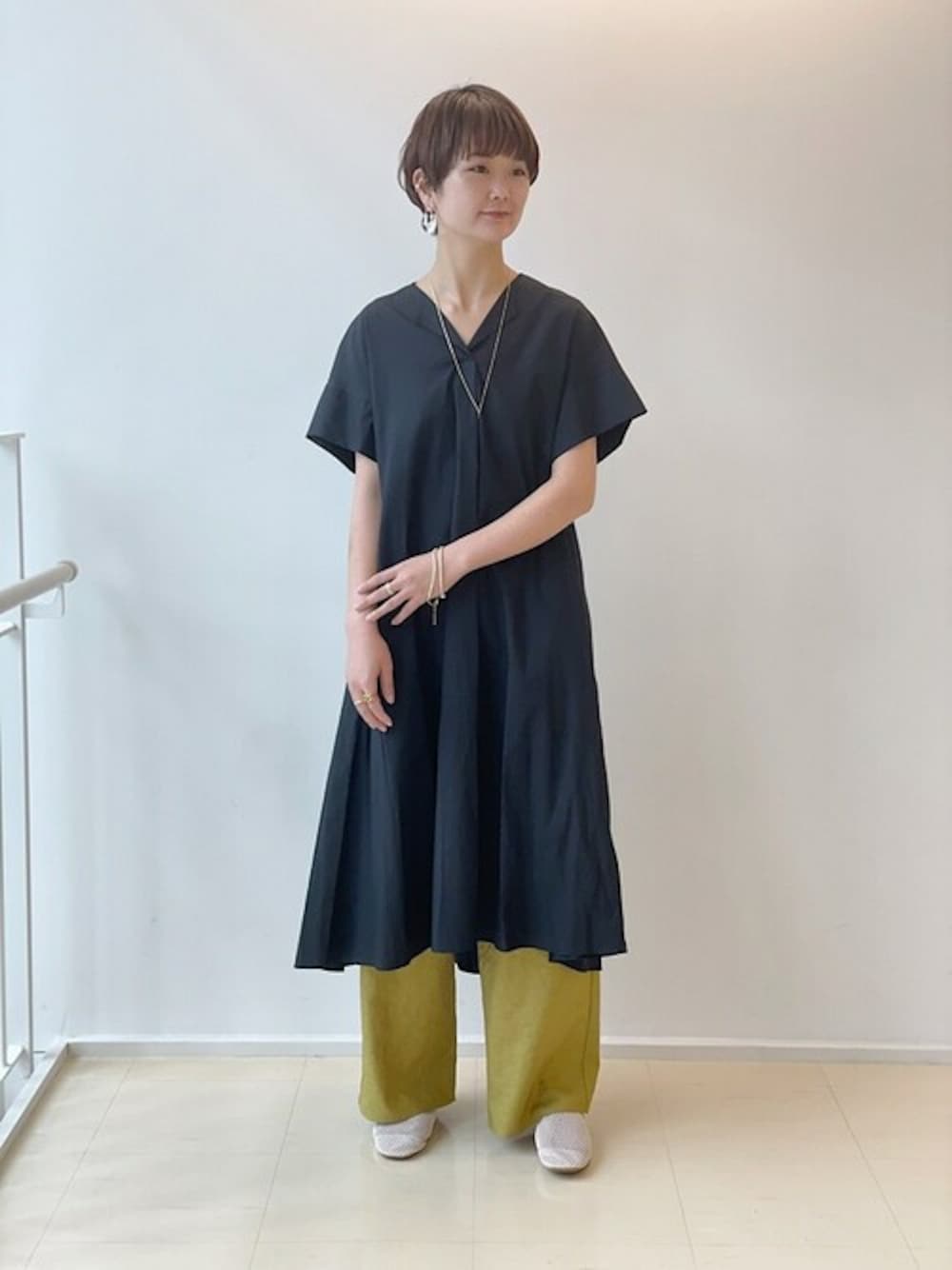 イエロー系のその他パンツ、ブラック系のワンピース、ベージュ系のスリッポンを着用したレディースの夏コーディネートの1枚目の写真