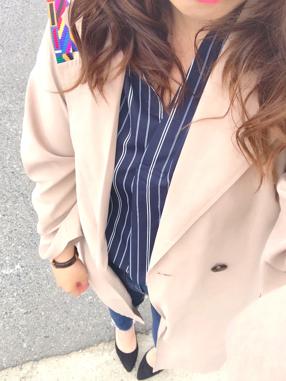 ベージュ系のトレンチコート、ブルー系のデニムパンツ、ブラック系のパンプスを着用したレディースの春コーディネートの1枚目の写真